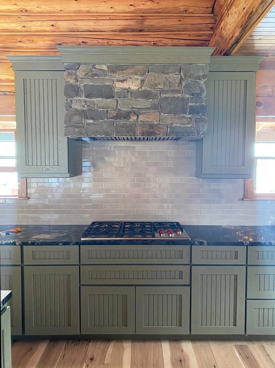 Kitchen with stove hood covered in natural stone.
