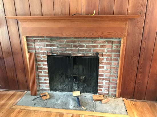 Brick fireplace with wood paneling