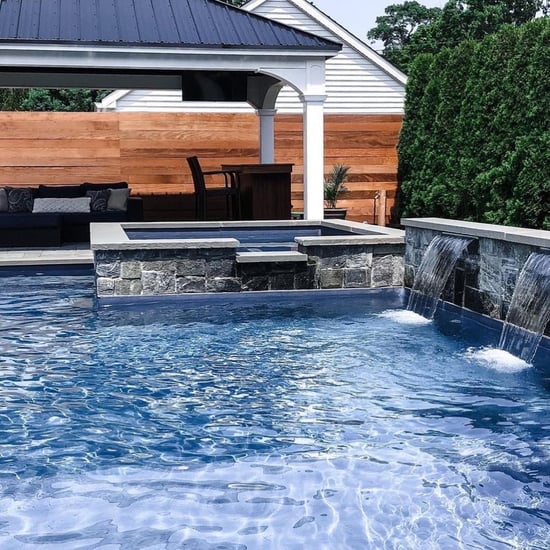 Pool design with natural stone on spill over spa and accent wall