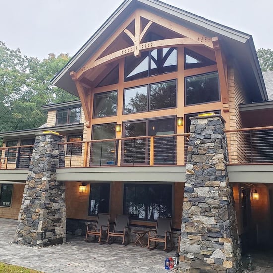 Home with wood accents and pillars made of natural stone