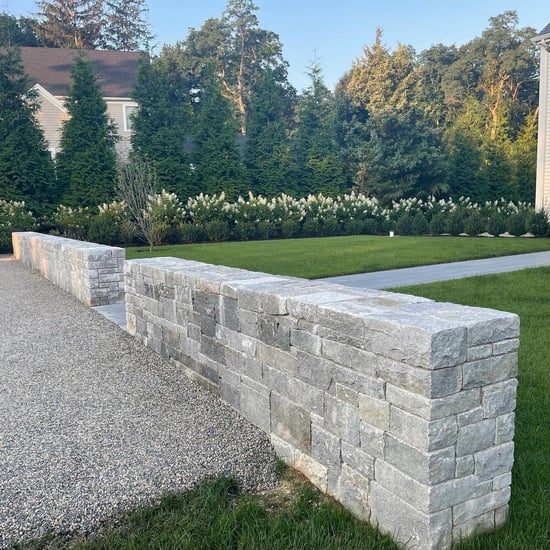 Natural stone wall in front of green landscape