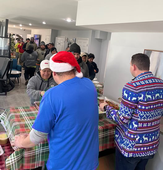 Tyler and Mike serve food to production team line