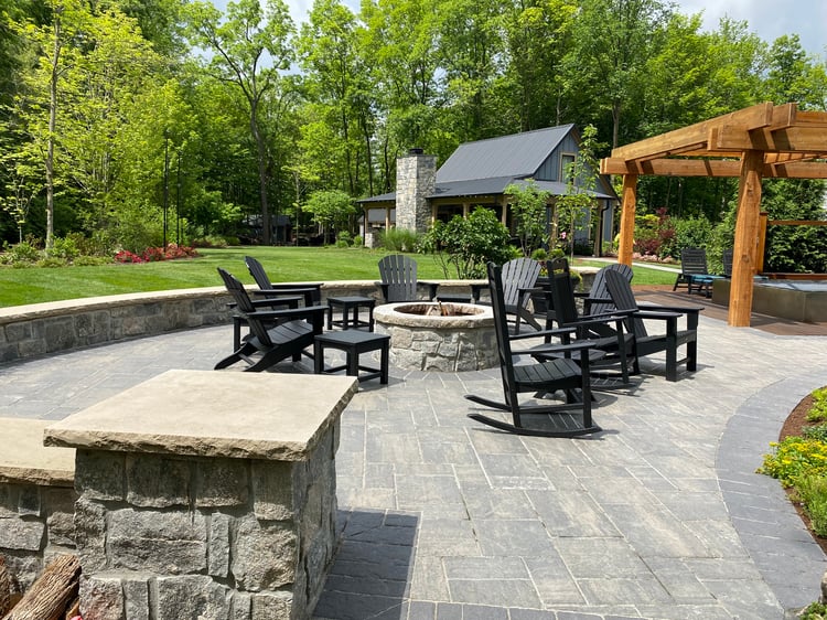 Outdoor fire pit, patio and seating area with guest home in the background.